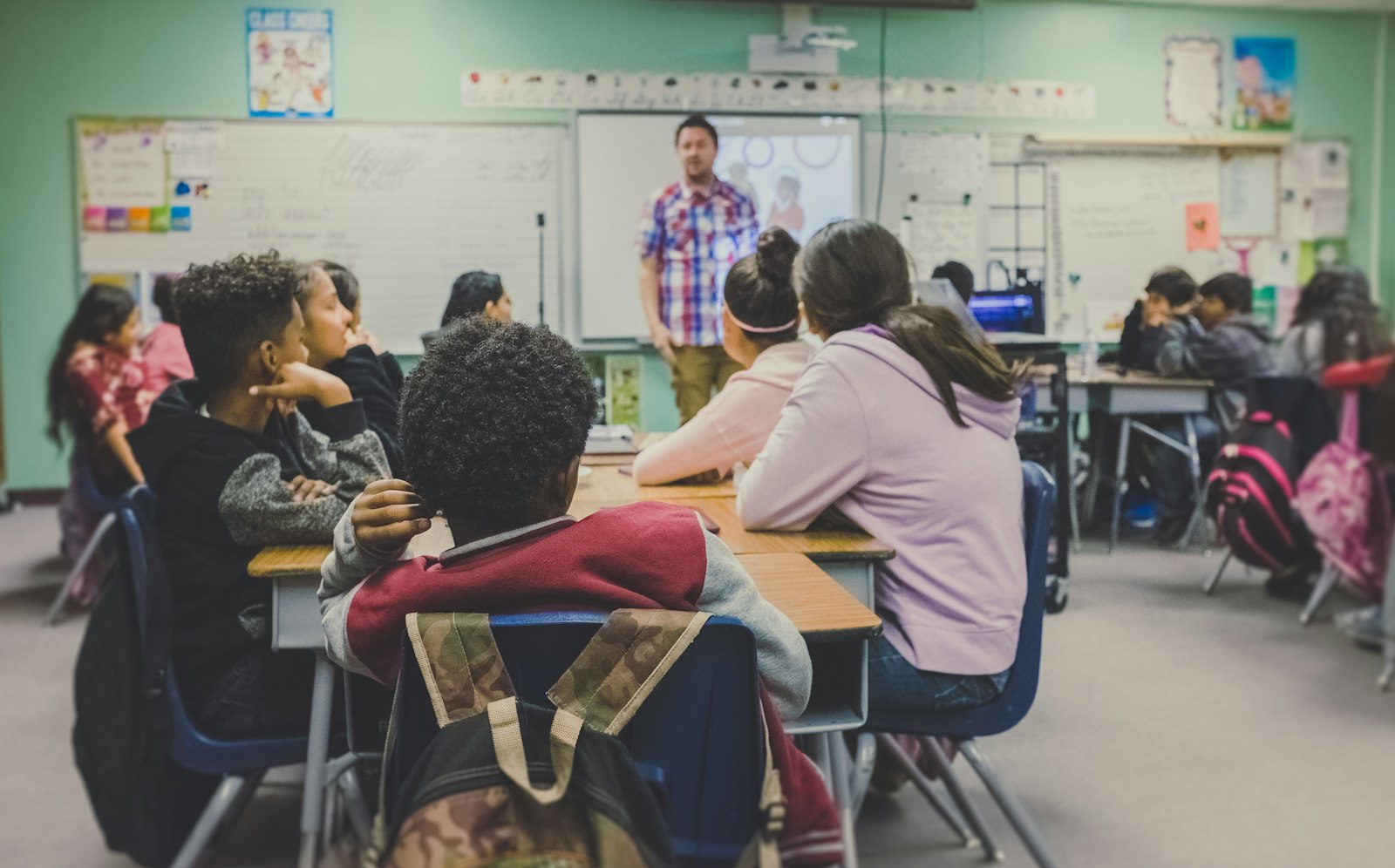 Students raising hands in a classroom